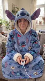 Femme dans le plaid Stitch qui tient la télécommande de chauffage